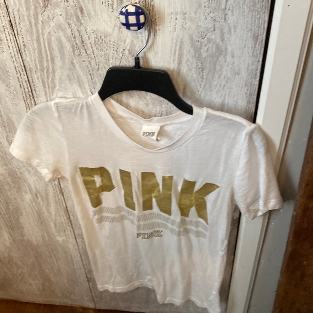 Pink ,white shirt sleeve gold letters. Woman’s size small/p